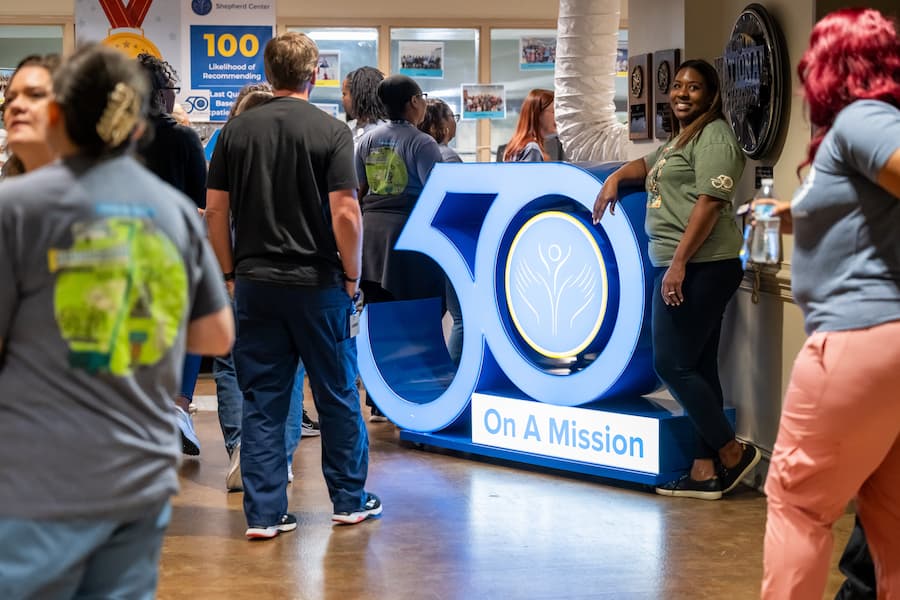 People gather indoors around a large blue 